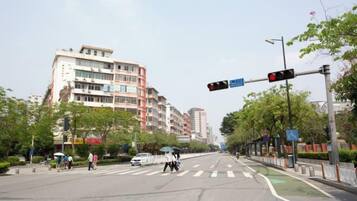 A multi-story building with a pedestrian crossing and traffic lights.