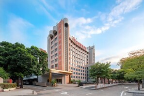 Un hôtel à plusieurs étages, doté d’une entrée imposante et d’un espace abrité.