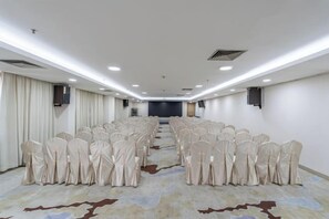 A conference room with rows of chairs, a carpeted floor, and a stage at the front. - Vienna International Hotel (Foshan Zemu Temple Metro Station Lingnan Xintiandi Branch) (Foshan)