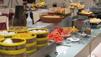 Un bufé con diferentes opciones de comida y una estación de café.