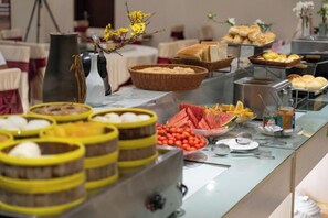 A buffet with various food items and a coffee station.