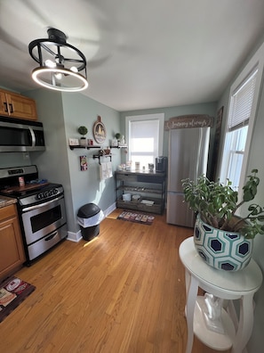 A kitchen with a built-in oven, microwave, and refrigerator. There is a wooden cabinet above the oven and a small potted plant on the counter. - Casino! Golf course view! Not located in a community with any additional fee. (Mount Pocono)