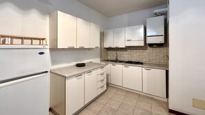Eine Küche mit weißen Schränken, einer Granit Arbeitsplatte, einem Herd und einem eingebauten Backofen.