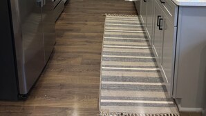 A modern kitchen with a stainless steel refrigerator, a built-in oven, and a sink with a faucet. - 3 Bedroom NEW CONDO MINUTES FROM Ole Miss Campus, The Square, and the Grove!! (Oxford)