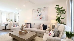 A modern living room with a beige sofa set, a coffee table, and a ceiling fan. - 3 Bedroom NEW CONDO MINUTES FROM Ole Miss Campus, The Square, and the Grove!! (Oxford)