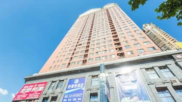A tall building with multiple floors, large windows, and several banners.