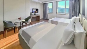 A hotel room with a large bed, a desk, a chair, and a small table. There is a window with curtains and a view of the outside. - Tiantian Chain Hotel Chongqing Xinan Hospital (Chongqing)