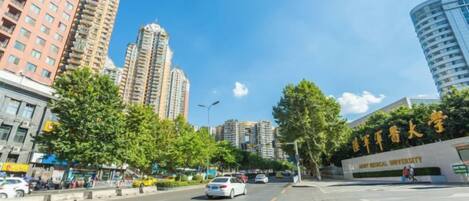 A street view with high-rise buildings, a clear sky, and a sign for a medical university.