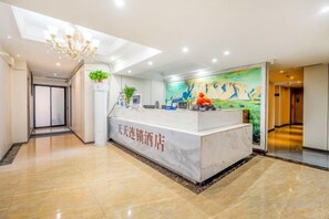 A hotel reception area with a marble counter, a chandelier, and a mural on the wall. - Tiantian Chain Hotel Chongqing Xinan Hospital (Chongqing)