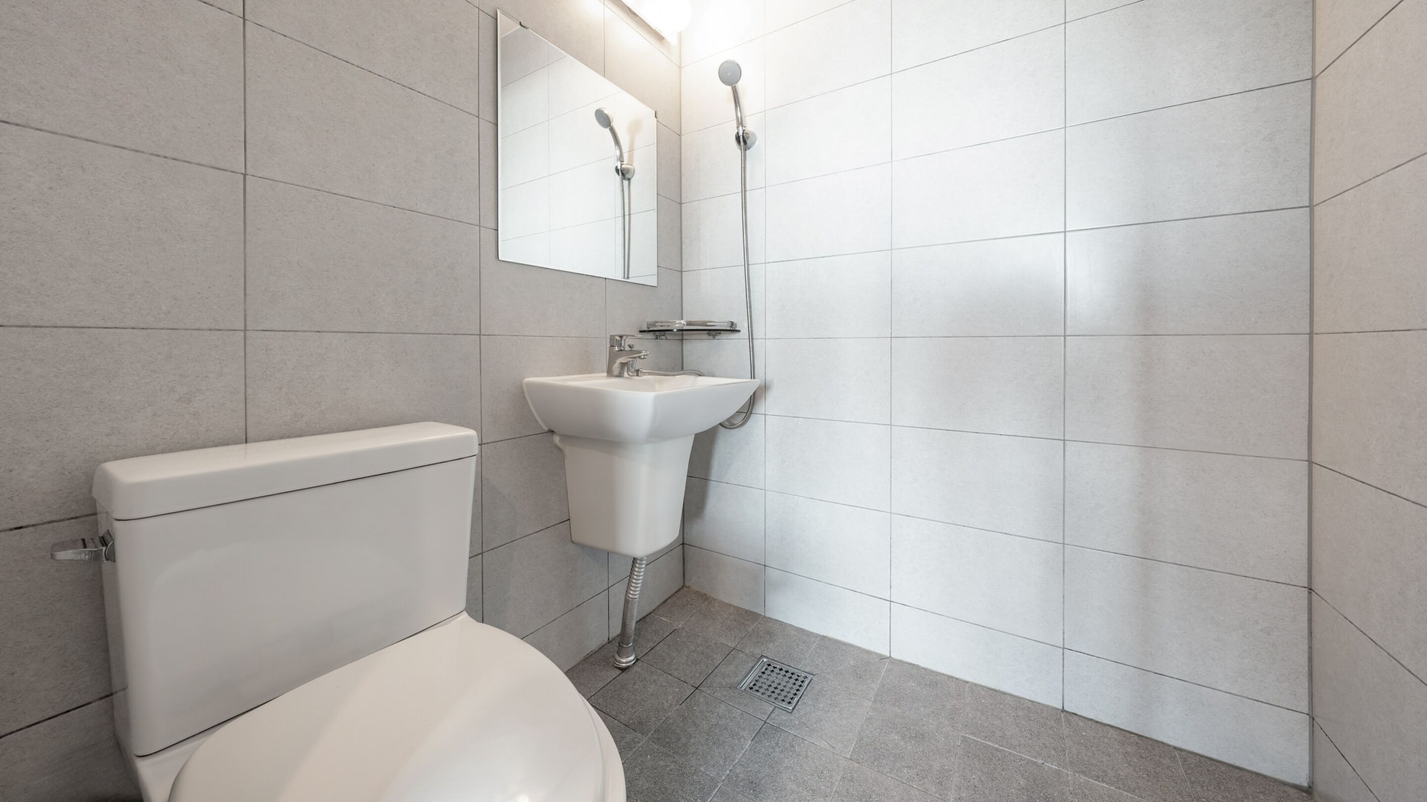 A modern bathroom with a toilet, sink, and shower.