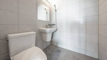 A modern bathroom with a toilet, sink, and shower.