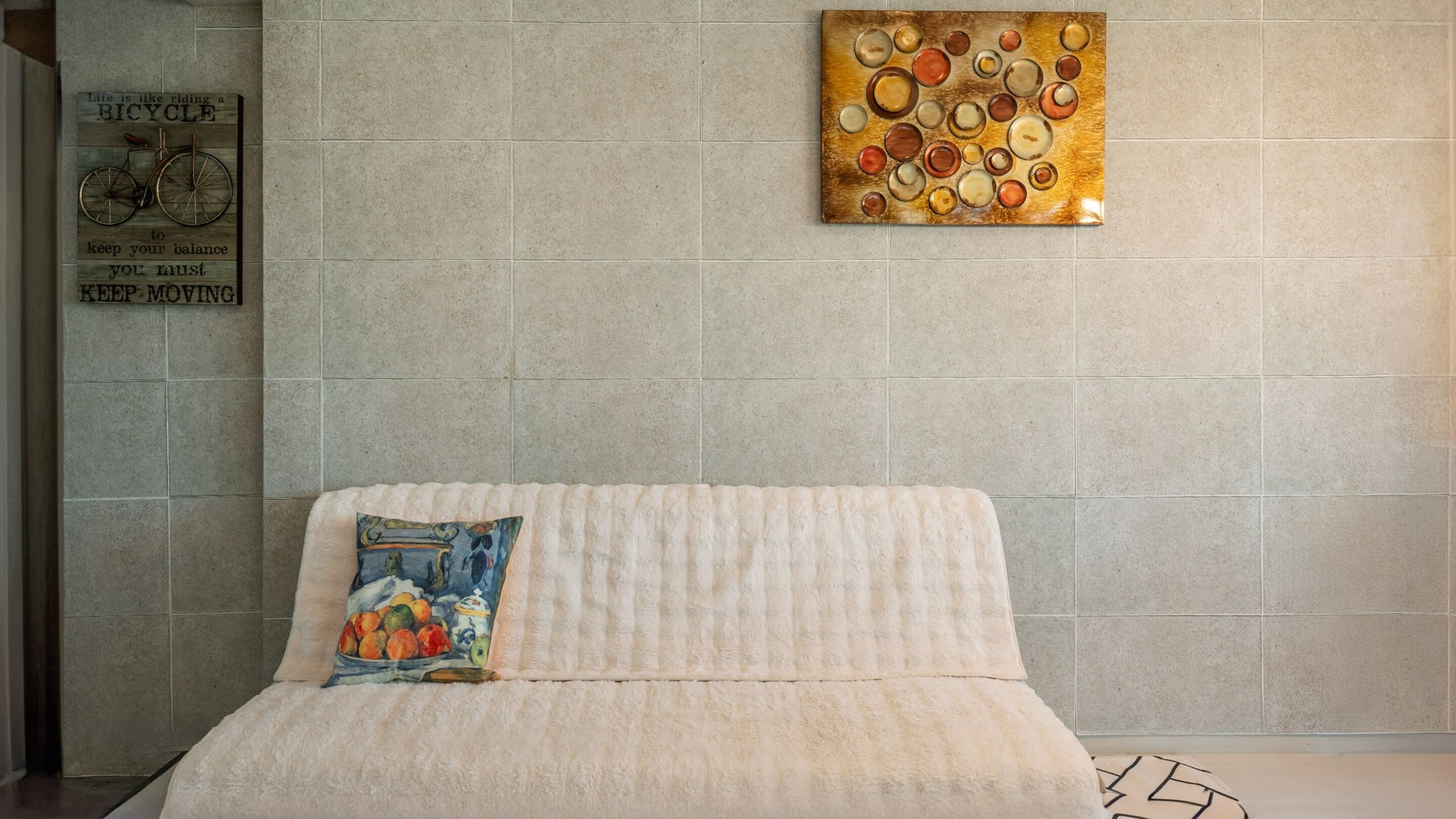 A room with a bed, a wall-mounted artwork, and a motivational quote.