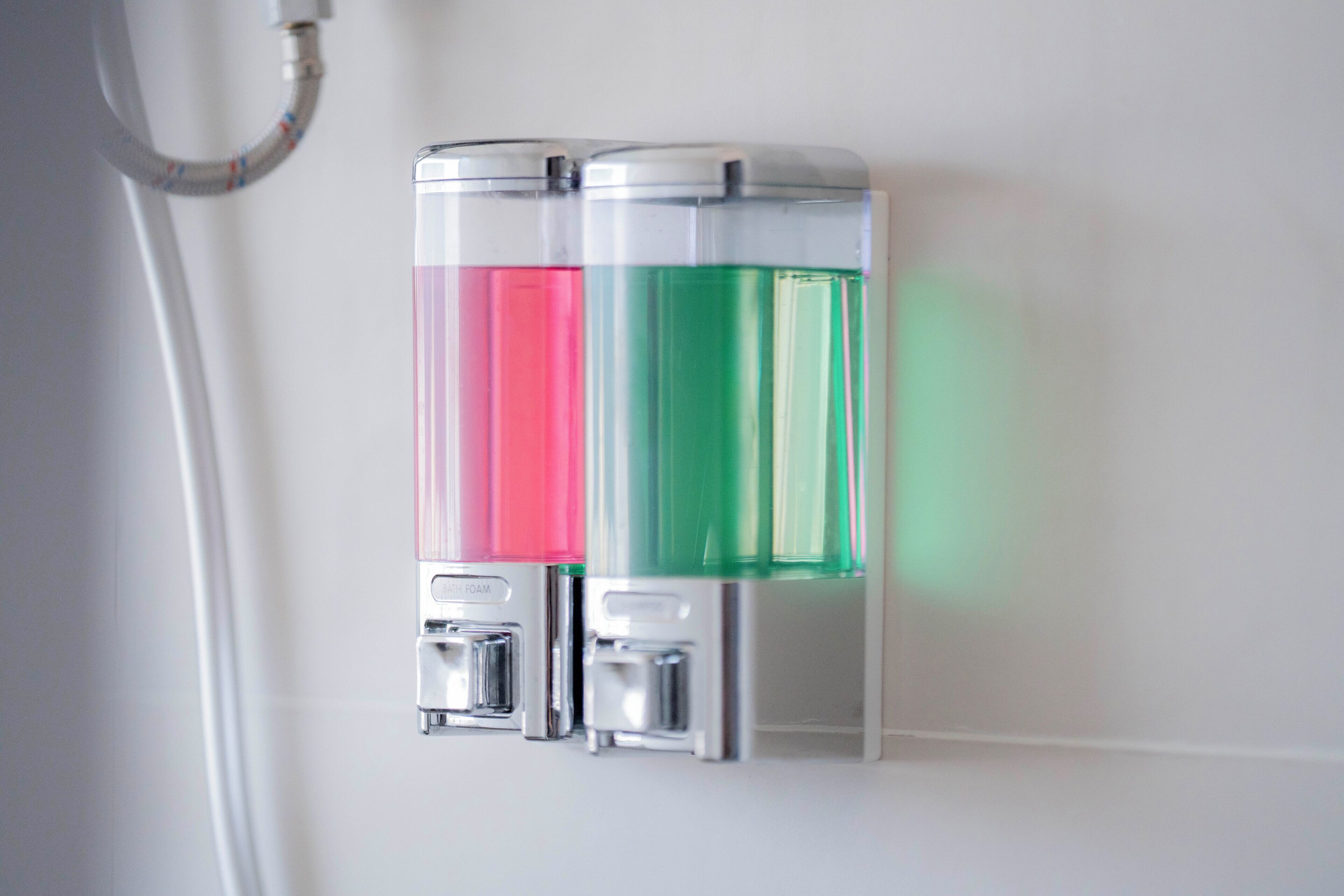 Two hand sanitizer dispensers mounted on a wall.
