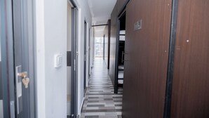 A corridor with a checkered floor, wooden doors, and a visible room number 705. - Bona Hostel PP (Phnom Penh)