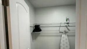 Une petite salle de bain bien éclairée, avec une porte blanche, un porte-serviettes et un espace douche.