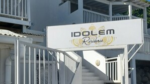 Eine weiße Treppe führt zu einem verschlossenen Eingang mit einem Schild, auf dem 'Idolém Residence' steht.