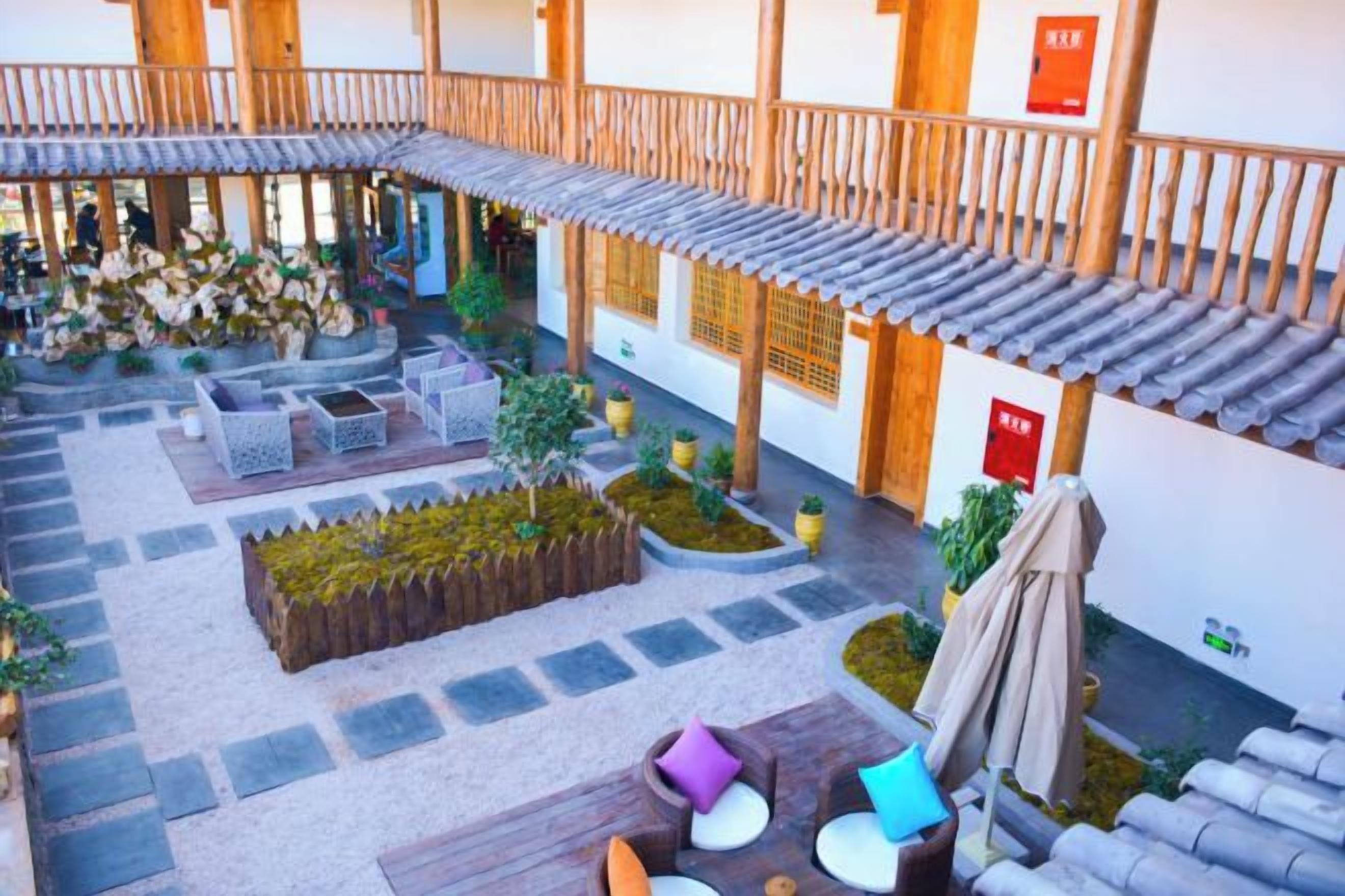A courtyard with outdoor seating, a wooden pergola, and a small garden area.