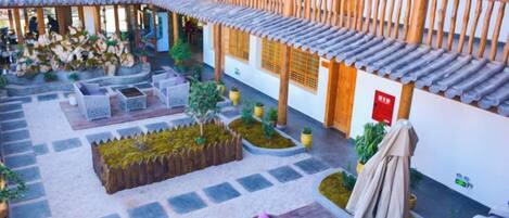 A courtyard with outdoor seating, a wooden pergola, and a small garden area.