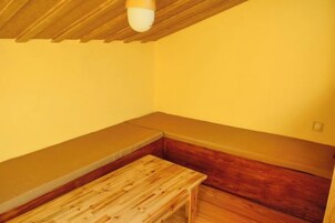 Una habitación con un banco de madera y techo bajo.