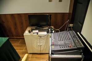 A control panel with a monitor and keyboard, a sound mixer, and a projection screen. - Regal Hotel (Jiamusi Railway Station Department Store) (Jiamusi)