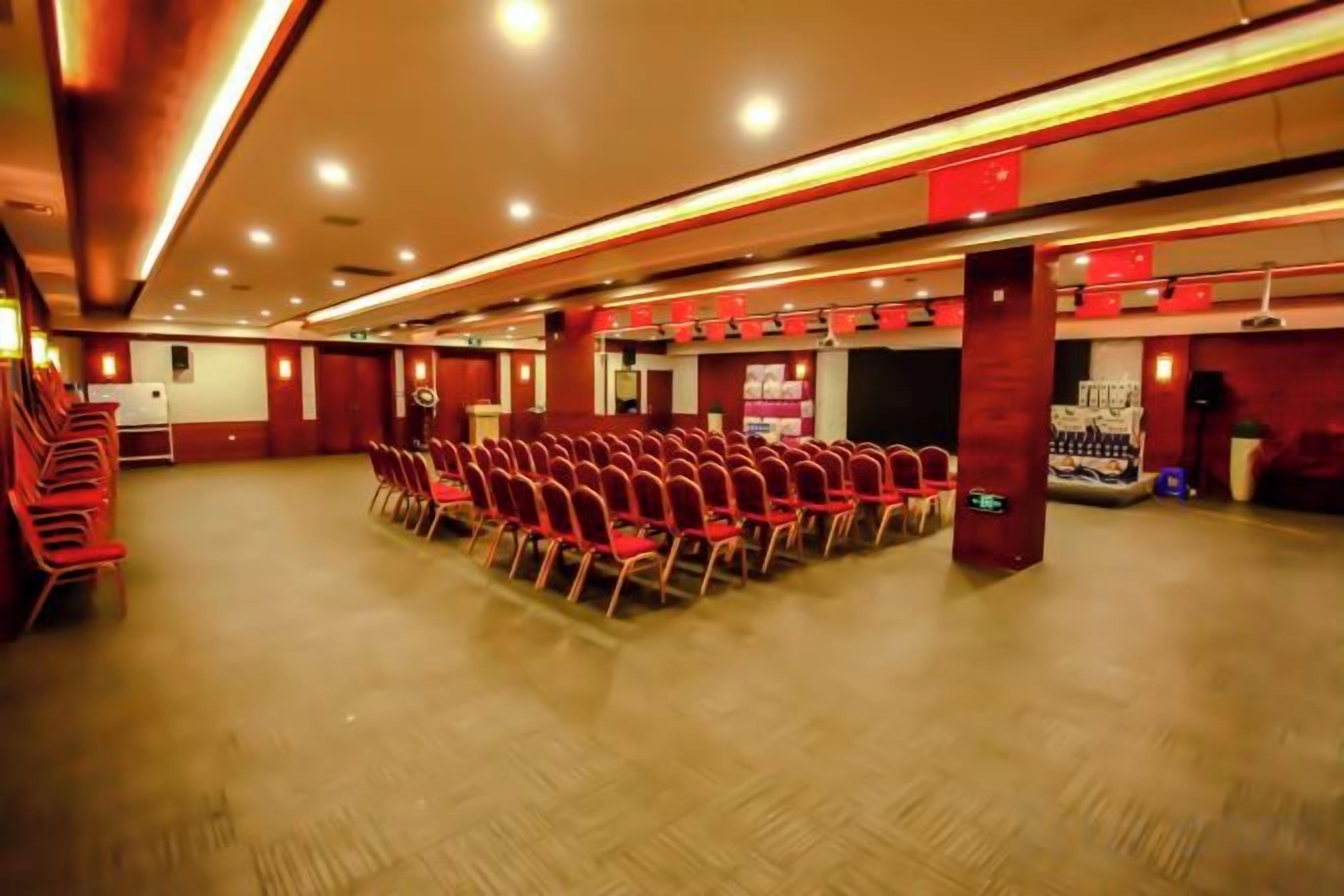 A conference room with rows of chairs, a stage, and a podium.