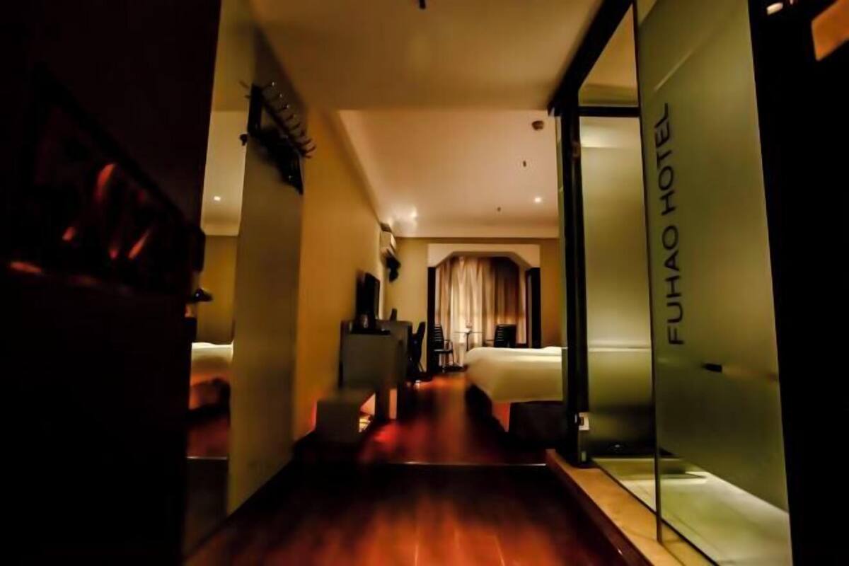 A hotel corridor with a bed, a desk, and a chair.