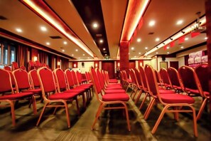 A conference room with rows of red chairs and a stage. - Regal Hotel (Jiamusi Railway Station Department Store) (Jiamusi)