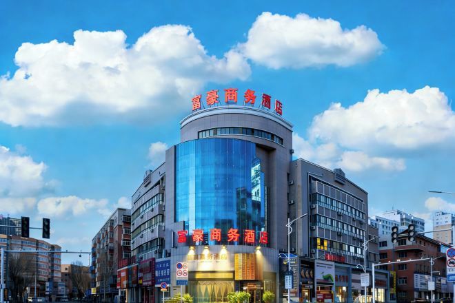 A modern hotel with a curved facade, large glass windows, and signage in a foreign language.
