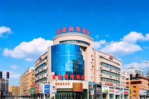 A hotel with a curved facade, multiple floors, and a prominent glass section. - Regal Hotel (Jiamusi Railway Station Department Store) (Jiamusi)