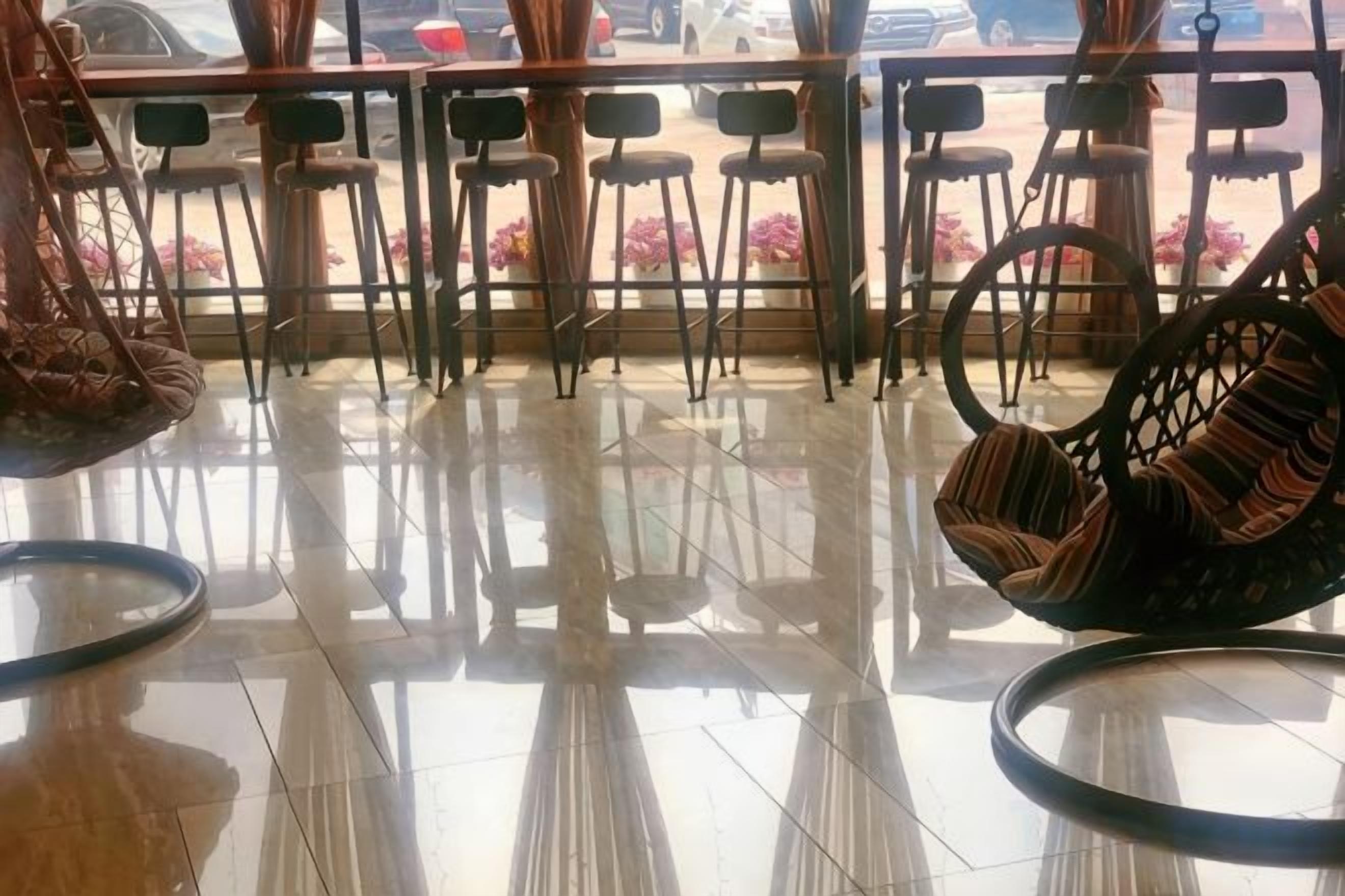 A clean, tiled floor with a seating area featuring chairs and a wicker chair.
