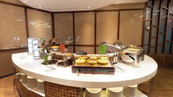 Un mostrador de buffet con diversos alimentos y salsas.