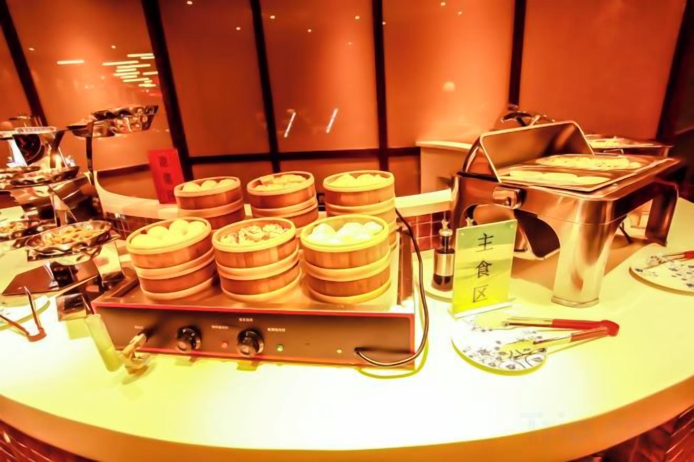 A buffet setup with multiple food stations and a steam table.