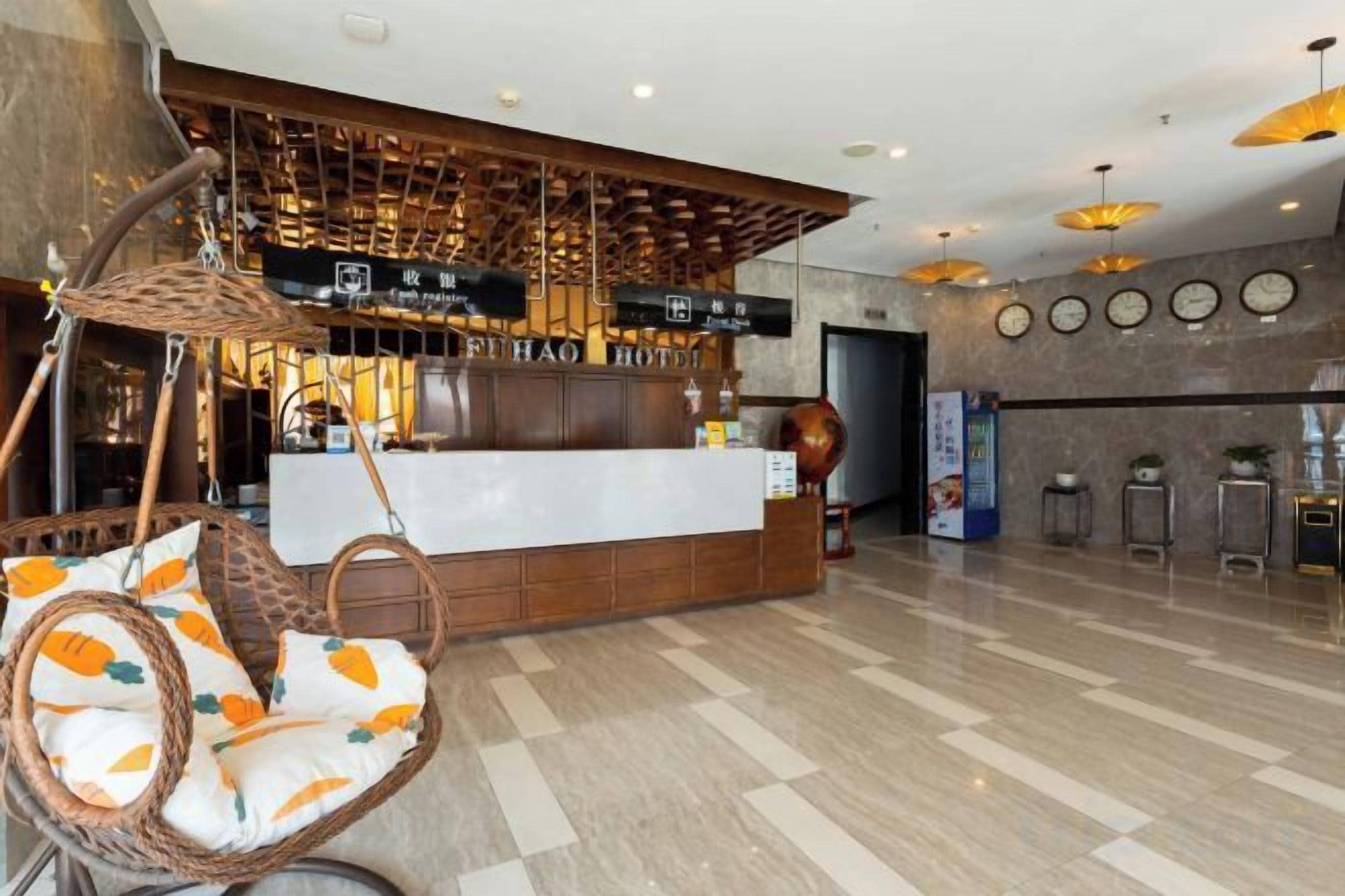 A reception area with a counter, a hanging chair with cushions, and a wall with clocks.