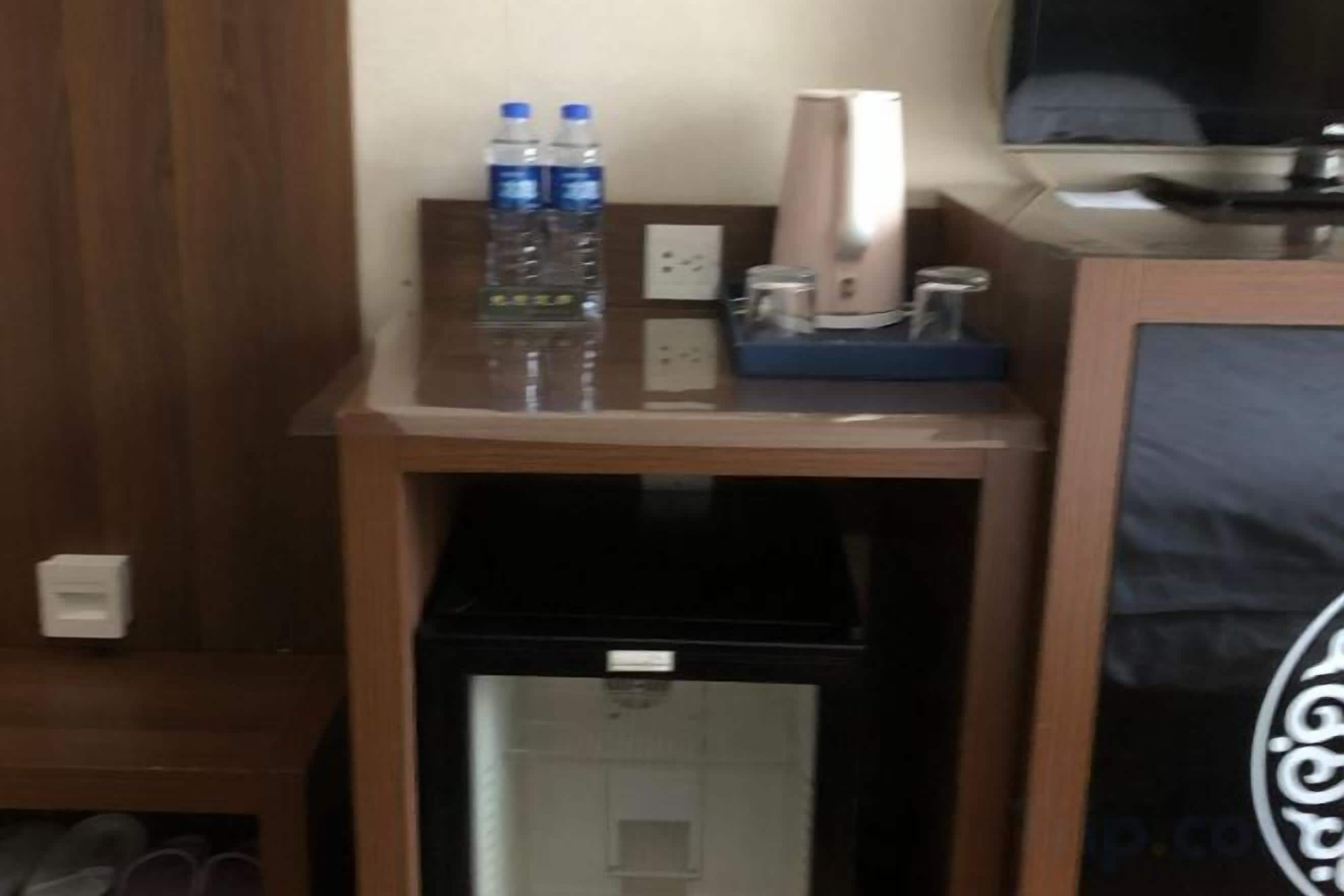 Een minibar met flessen water en een koffiezetapparaat.