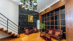 A modern interior with a staircase, wooden flooring, a chandelier, and traditional furniture. - Regal Hotel (Jiamusi Railway Station Department Store) (Jiamusi)