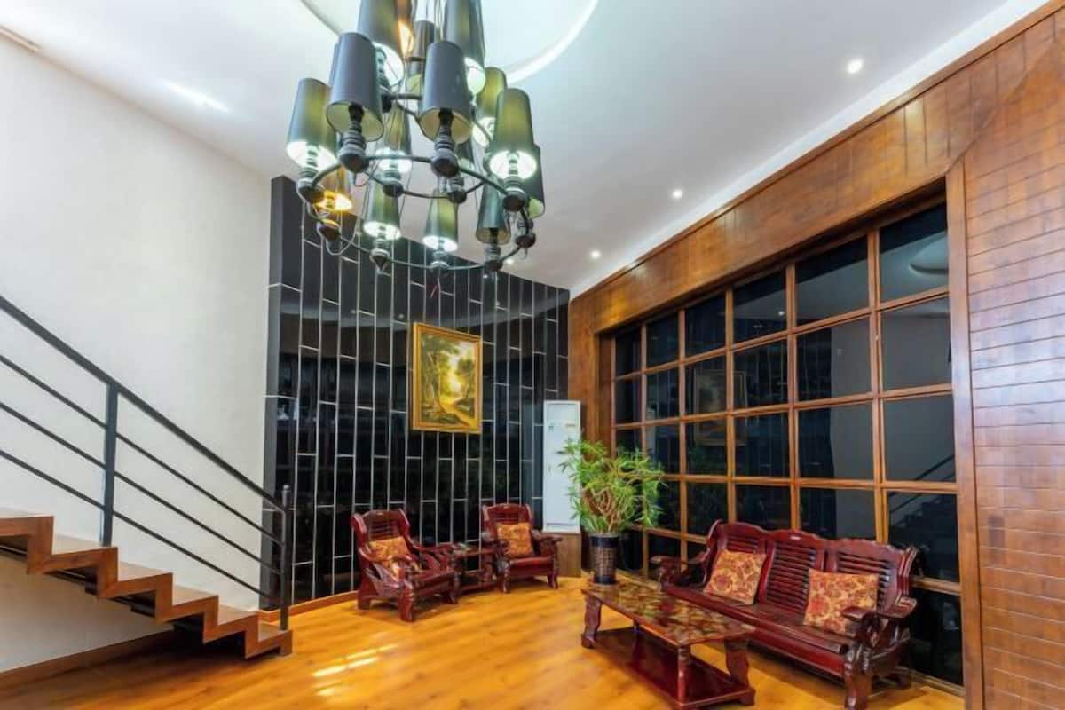 A modern interior with a staircase, wooden flooring, a chandelier, and traditional furniture.