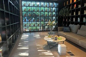 A modern interior with a sofa, coffee table, and a bookshelf. - Youzhi Hotel (Hangzhou)