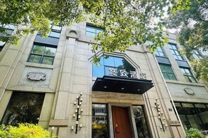 A building with a prominent entrance, a sign with Chinese characters, and a modern architectural design.