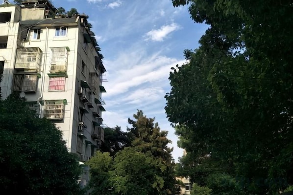 A multi-story building with balconies, surrounded by trees. - Youzhi Hotel (Hangzhou)