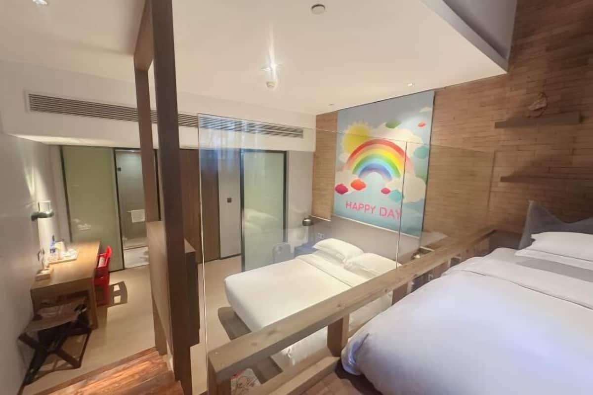 Quarto de hotel moderno com cama, escrivaninha, espelho e um letreiro com a inscrição 'Happy Day'.