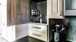 A kitchen with wooden cabinets, a stainless steel microwave, and a spice rack. - Modern Minimalist Home 4BR 5 Beds, AC Comfort & Wifi (Burlington)