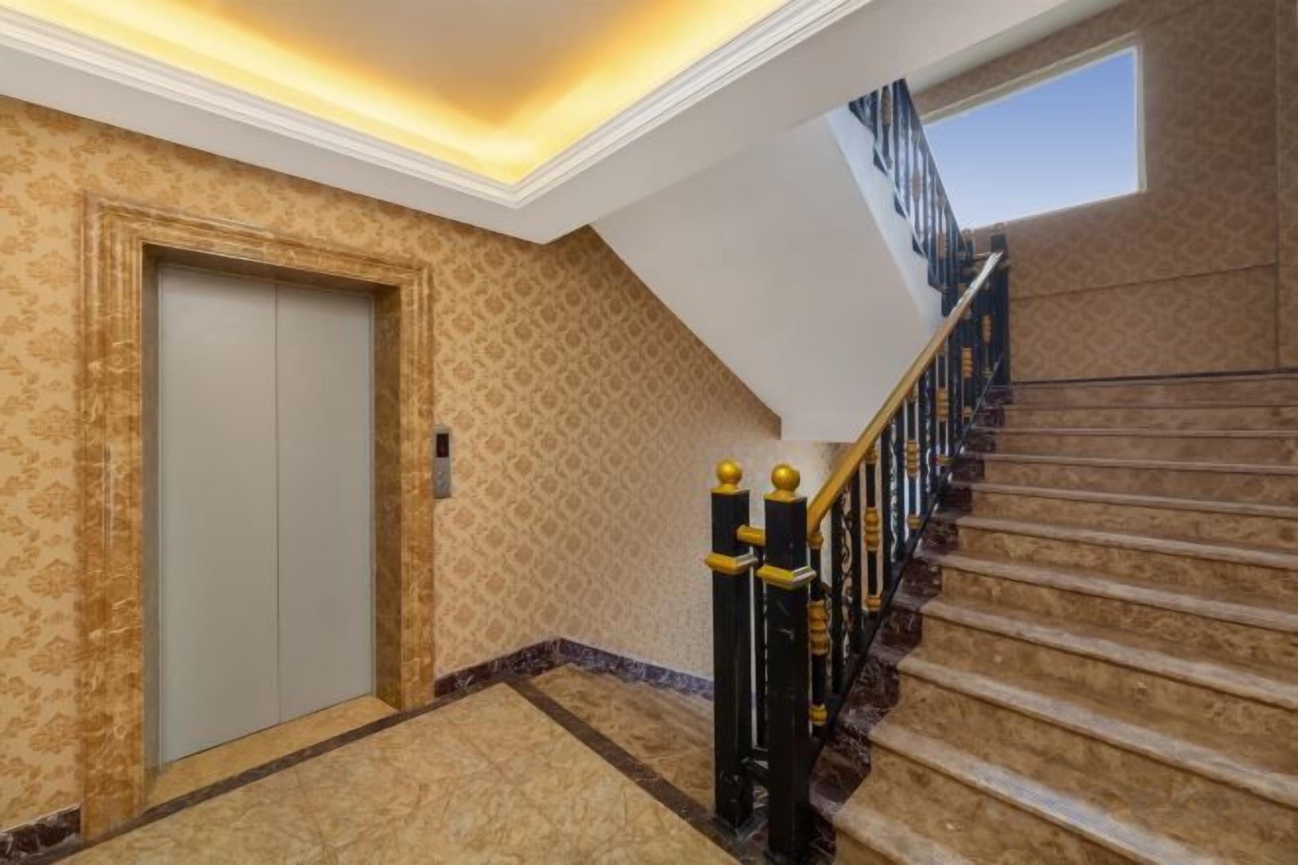 A hotel interior with a carpeted staircase, a door, and a patterned wall.