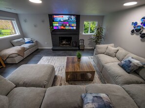 A modern living room with a fireplace, a flat-screen TV, and comfortable seating. - Stylish Remodeled 2BR Retreat - Near Seattle - Peaceful, Clean, & Modern (Shoreline)