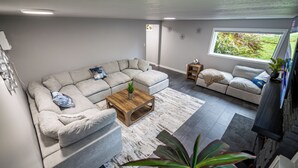 Una sala de estar moderna con un sofá modular, una mesa de centro y una mesita auxiliar.
