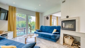 A modern living room with a blue sofa, a white coffee table, and a fireplace. - Cosy Home D&D by Interhome (Brod Moravice)
