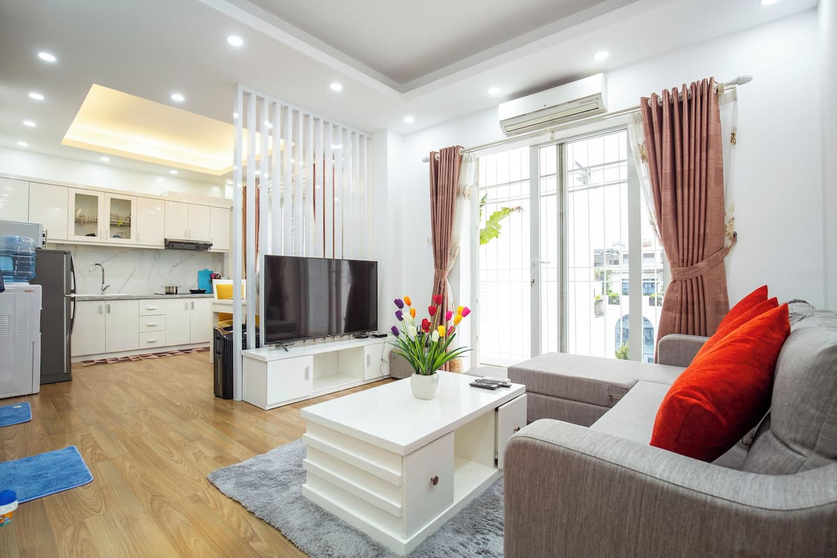 A modern living room with a flat-screen TV, a sofa, and a coffee table.