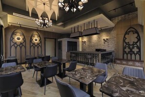 A restaurant interior with marble tables, black chairs, and a bar area. - Nottingham Ocean Castle B&B (Hualien)