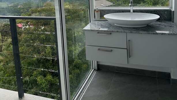 Een badkamer met een groot raam dat uitzicht biedt op een bergachtig landschap.
