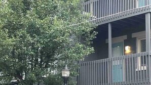 Un immeuble à plusieurs étages doté d’un balcon, d’un lampadaire et d’un panneau indiquant un espace de stationnement.