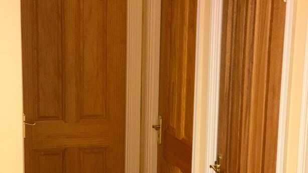 A hallway with two wooden doors, one closed and one partially open. - Room-ensuite With King Bed 2 (Dublin)